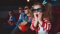 Family mom father and children are watching a projector, TV, cinema, movies with popcorn in the cinema. Royalty Free Stock Photo