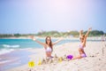 Family of mom and girl making sand castle at tropical white beach Royalty Free Stock Photo