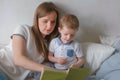 Family mom and son toddler read books laying on the bed. Family reading time. Royalty Free Stock Photo