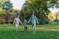 a family mom and 2 sons are having fun, running in the park and jumping. Sons, children, mom, run, play, rejoice, enjoy Royalty Free Stock Photo