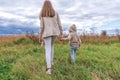 Family mom woman with a little boy 4-5 years old on weekends walk in the park field, background green grass. Warm casual Royalty Free Stock Photo