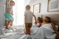 Family morning at home. children jumping on a bed in parents bedroom Royalty Free Stock Photo