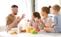 Young happy family having healthy breakfast in morning at home