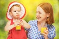 Family mother and baby daughter drinking orange juice in the sum Royalty Free Stock Photo