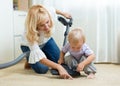 Family mother and child cleaning the room with vacuum-cleaner - housework