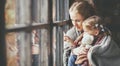 Family mother and child daughter look out window on rainy autumn Royalty Free Stock Photo