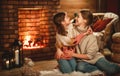 Family mother and child reading book and drink tea on winter evening by fireplace Royalty Free Stock Photo