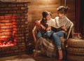 Family mother and child reading book and drink tea on winter evening by fireplace Royalty Free Stock Photo