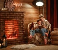 Family mother and child reading book and drink tea on winter evening by fireplace Royalty Free Stock Photo