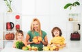 Family mother and child daughter and son blended smoothie with healthy fruits ingredients on kitchen. Cute children with Royalty Free Stock Photo