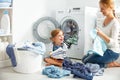 Family mother and child girl in laundry room near washing machi Royalty Free Stock Photo