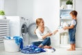 Family mother and child girl in laundry room near washing machi Royalty Free Stock Photo