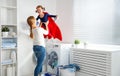 Family mother and child girl little superhero helper in laundry