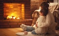 family mother and child hugs and warm on winter evening by fireplace. Royalty Free Stock Photo