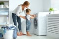 family mother and child little helper in laundry room near washing machine Royalty Free Stock Photo