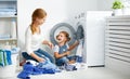 Family Mother And Child Little Helper In Laundry Room Near Washing Machine