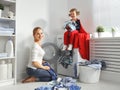 Family mother and child little superhero helper in laundry room