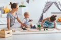 Family mother and children play a toy railway in playroom Royalty Free Stock Photo