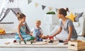 Family mother and children play a toy railway in playroom Royalty Free Stock Photo