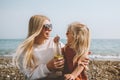 Family mother and daughter cheerful laughing travel outdoor summer vacations mom and child drinking smoothie on beach Royalty Free Stock Photo