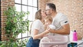 Family of mother, father and baby doing laundry kissing at laundry room Royalty Free Stock Photo