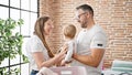 Family of mother, father and baby doing laundry at laundry room Royalty Free Stock Photo