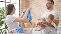 Family of mother, father and baby doing laundry at laundry room Royalty Free Stock Photo