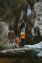 Family mother and father with child enjoying waterfall view hiking together outdoor travel lifestyle vacations