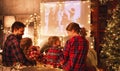 Family mother father and children watching projector, film, movies with popcorn in christmas evening at home
