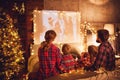 Family mother father and children watching projector, film, movies with popcorn in   christmas evening   at home Royalty Free Stock Photo