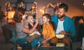 Family mother father and children watching projector, TV, movies with popcorn in evening at home