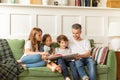 Family mother, father and kids reading interesting book