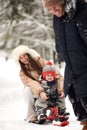 Family of mother, father and son having fun in snowy winter wood with cheerfull pet dog. Royalty Free Stock Photo