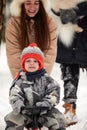 Family of mother, father and son having fun in snowy winter wood with cheerfull pet dog. Royalty Free Stock Photo