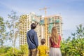 Family mother, father and son looking at their new house under construction, planning future and dreaming. Young family Royalty Free Stock Photo