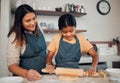 Family, mother and girl baker with a pin rolling dough helping baking a cake, food or cookies in a house kitchen. Child Royalty Free Stock Photo