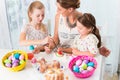 Family with mother and kids coloring Easter eggs