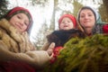 Family with mother, teenage girl, and little daughter dressed in stylized medieval peasant clothing in winter forest