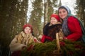 Family with mother, teenage girl, and little daughter dressed in stylized medieval peasant clothing in winter forest