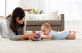 Mother and baby son playing with ball at home