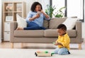 Baby playing toy blocks and mother with smartphone Royalty Free Stock Photo