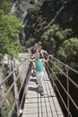 Family In Mountains Crossing Bridge