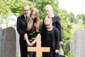 Family mourning at grave on cemetery