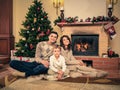 Family near fireplace in Christmas decorated house Royalty Free Stock Photo