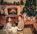 Family near fireplace in Christmas decorated house Royalty Free Stock Photo