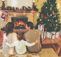 Family near fireplace in decorated house interior Royalty Free Stock Photo