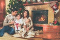 Family near fireplace in decorated house interior Royalty Free Stock Photo