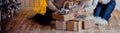 Family near a fireplace and a Christmas tree parses gifts sitting on the floor.family near the Christmas tree, hugs and keeps gift Royalty Free Stock Photo