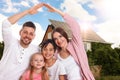 Family near their house with solar panels. Alternative energy source