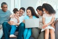 Family never loses its magic. a beautiful family using a laptop while bonding on a sofa at home.